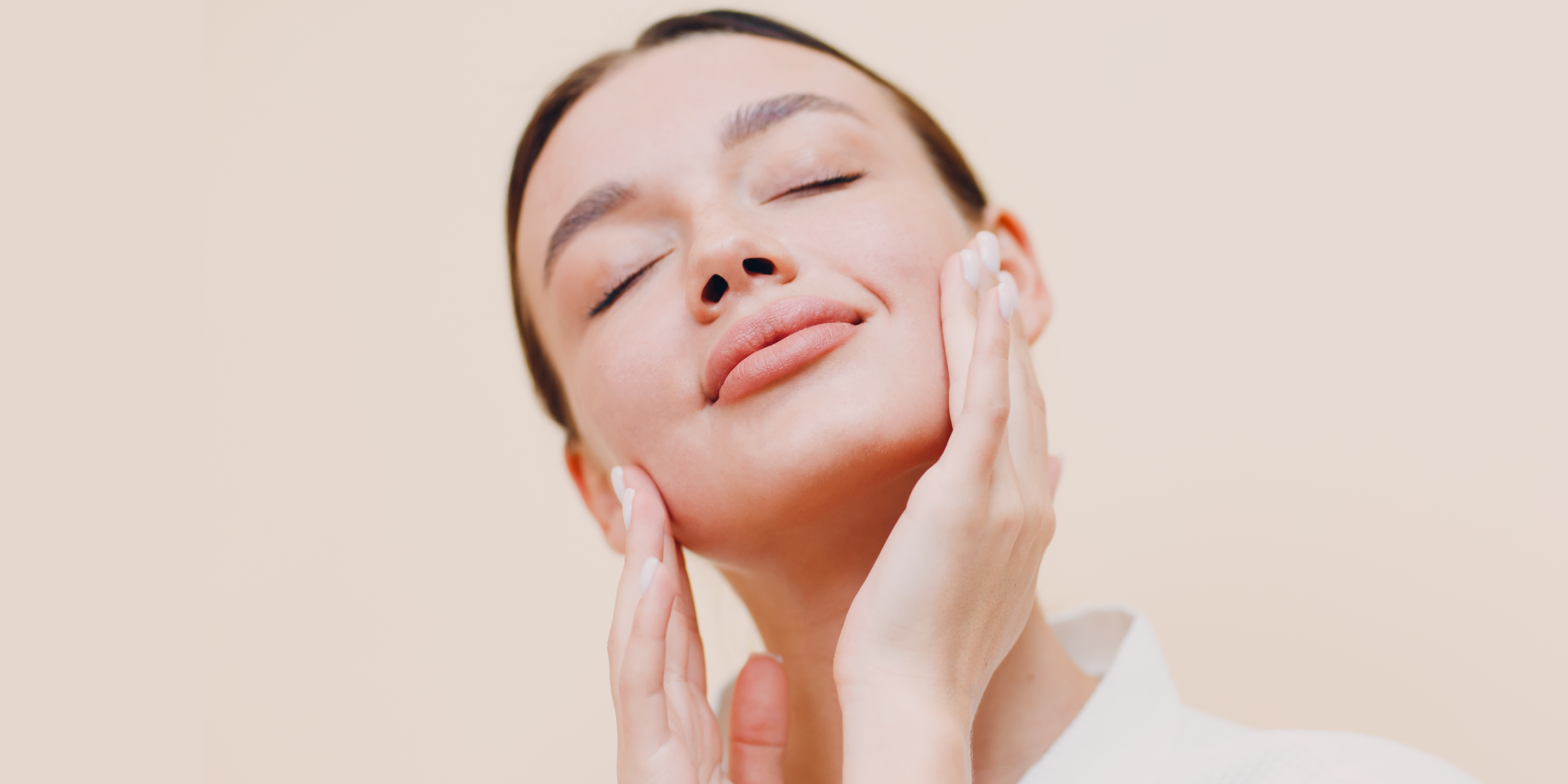 1 - RiKo Aesthetics Person gently holding their face, showing smooth, healthy skin.